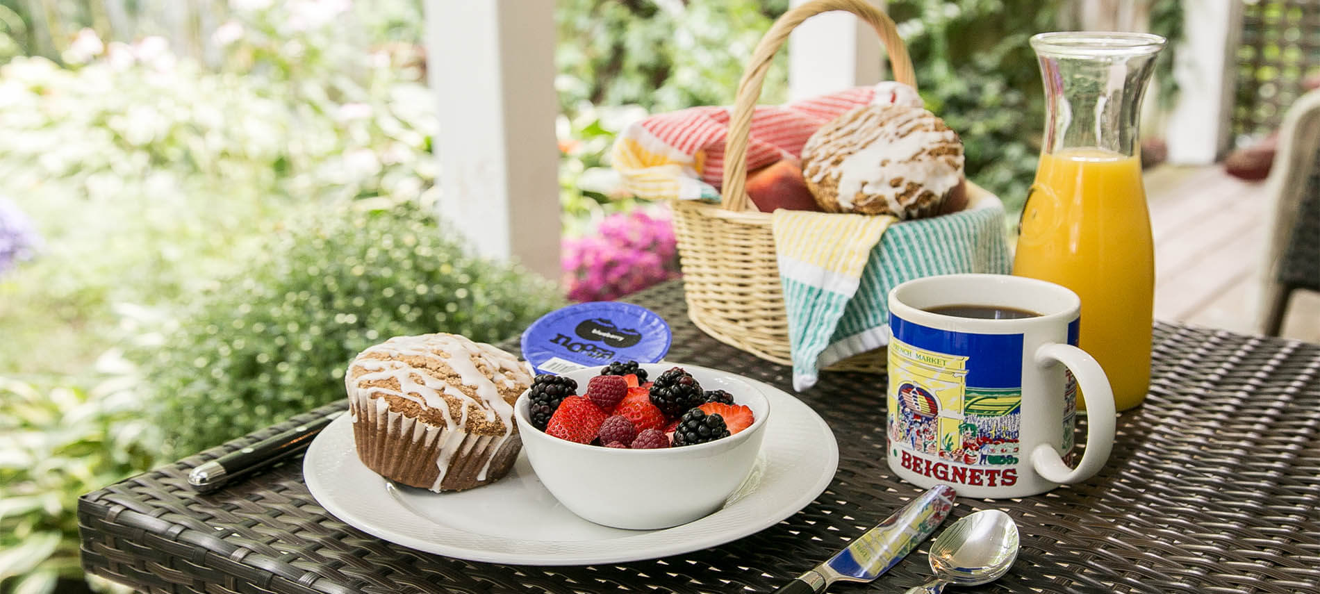 Mixed berries with muffin, coffee, orange juice and bread basket.